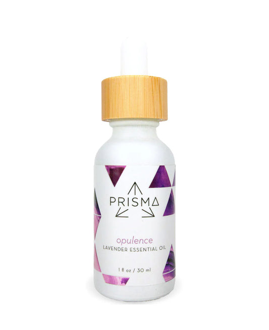 Front view photo of a Prisma Lavender Essential Oil bottle showing a white bottle with a white and purple metallic label reading prisma opulence lavender essential oil 1 fl oz / 30 ml. Bottle has a bamboo lid with a white dropper on top. Background is white.